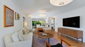 Una sala de estar moderna con un sofá, una mesa de centro y un televisor.