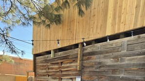 A hot tub in a backyard with a wooden fence and a bench.