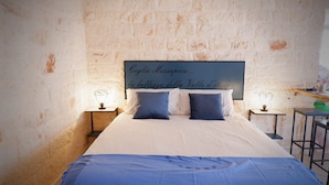 A bedroom with a large bed, two bedside tables with lamps, and a wall with a text mural.