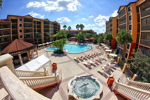 Relax by the rooftop pool surrounded by lounge chairs and lush greenery.