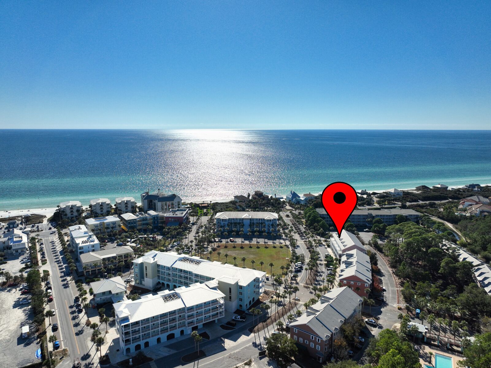 An aerial view of a coastal town with buildings, roads, and a beach.