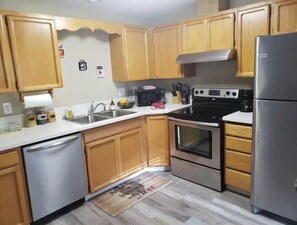 Fully equipped kitchen with a dishwasher, microwave, oven, and refrigerator.