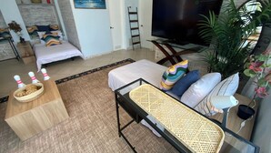 A modern living room with a sofa, a TV, a dining table, and a large window. - MANASOTA BEACH 1 MINUTE AWAY! (Englewood)