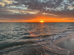 A sunset over a calm sea with waves gently touching the shore. - BEACH 1 MINUTE AWAY! WE WORK WITH YOUR BUDGET CONTACT NOW! (Englewood)