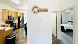 A modern kitchen with wooden cabinets, a microwave, and a stainless steel refrigerator.