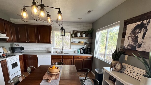 Una cocina moderna con armarios de madera, una mesa de comedor y una araña.