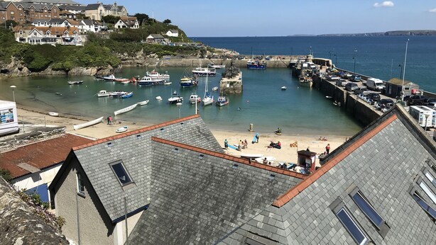 Un pueblo costero con puerto deportivo, playa y edificios.