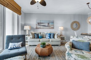 Ein Wohnzimmer mit einer Couch, Sesseln, einem Couchtisch und einem Bild an der Wand.