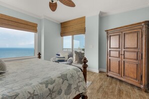 Ein Schlafzimmer mit einem großen Bett, einem Holzschrank und Blick aufs Meer.