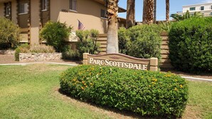 Schild für Parc Scottsdale mit gepflegtem Rasen und Palmen.