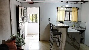 A compact kitchen with a marble island, a bench, and a potted plant. - Perfect location for low budget travel (Quepos)
