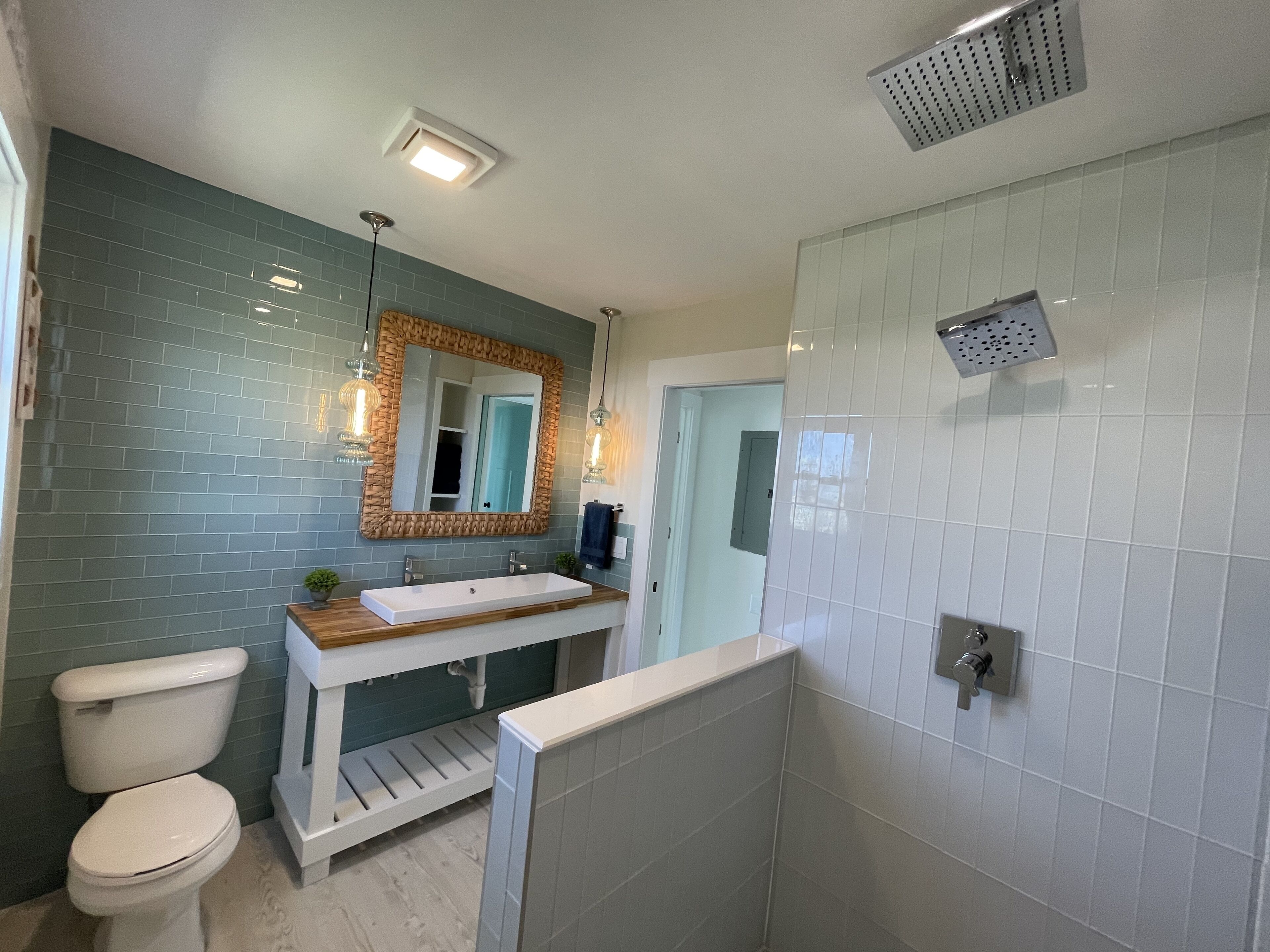 A bathroom with a white sink, a toilet, and a shower.