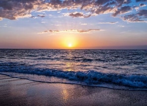 Uma praia com ondas ao pôr do sol.