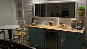 Une cuisine compacte avec un coin repas, une grande fenêtre et un luminaire au plafond.