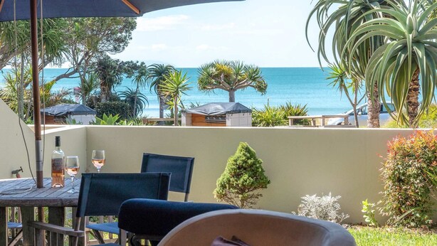 A patio with outdoor seating, a view of the sea, and various plants. - The Sands - Apartment 23 - Onetangi Beach (Waiheke Island)