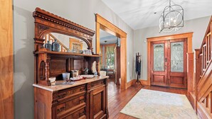 A spacious room with a large wooden dresser, a mirror, and a chandelier. - The Laurel Oak Inn Bed and Breakfast (Gainesville)