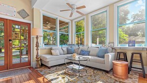 A living room with a sectional sofa, a coffee table, and a ceiling fan. - The Laurel Oak Inn Bed and Breakfast (Gainesville)