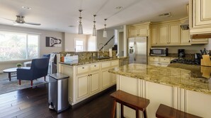 A modern kitchen with granite countertops, stainless steel appliances, and a central island.