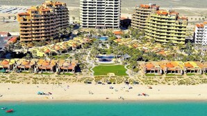 Een resort met meerdere gebouwen, een centraal gelegen zwembad en een strandgedeelte.