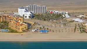 A coastal resort with multiple hotel buildings, a beach, and a pool area. - Fun Sandy Beach Condo B204 at Casa Blanca (Puerto Peñasco)