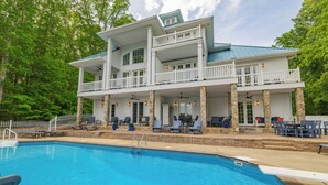 A two-story building with a pool, outdoor seating, and a covered patio area. - Blue Heaven (Littleton)