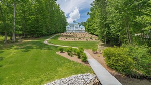 A large, multi-story house surrounded by lush greenery and a well-maintained lawn. - Blue Heaven (Littleton)