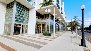 A modern building with large glass windows, a visible address sign, and a well-maintained sidewalk. - Design District Bay View Cielo Stays (Miami)