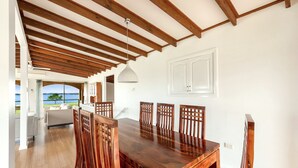 A dining area with a wooden table and chairs, white walls, and a view of the outdoors. - 3 Bedroom Waterfront House (Greenwell Point)