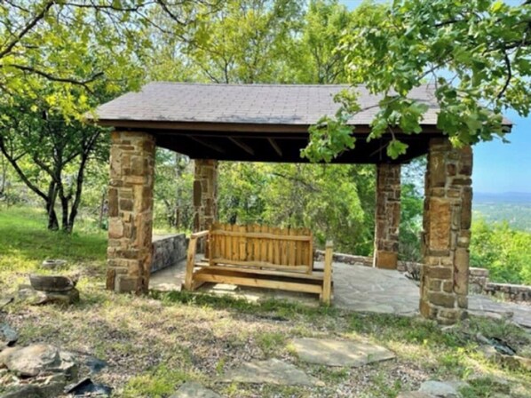 A stone gazebo with a wooden bench, surrounded by trees and a view of the landscape. - Two bedroom cottage on 8 acres with amazing views. (Paris)