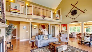 A spacious living area with a staircase, a fireplace, and a dining area. - Luxury Mountaintop Estate – Spacious Retreat with Breathtaking Views (Bovina Center)