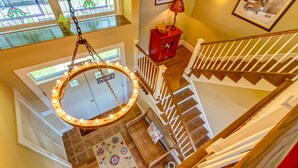 A multi-level interior with a staircase, a hanging light fixture, and a patterned rug. - Luxury Mountaintop Estate – Spacious Retreat with Breathtaking Views (Bovina Center)