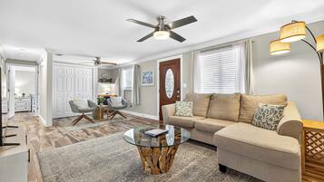 A living room with a sofa, coffee table, and a ceiling fan.