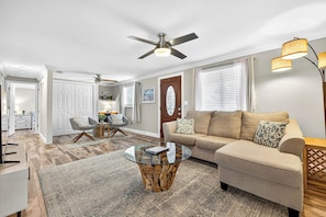 A living room with a sofa, coffee table, and a ceiling fan. - Gorgeous 3 bedroom Home With Heated Pool And Pond Access (Largo)