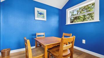A dining area with a blue wall, a wooden table, and four chairs.