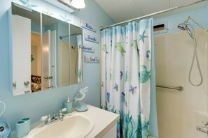 A bathroom with a white sink, a mirror, and a shower curtain with sea creatures. - Resort Pool & Sports Courts! Port Charlotte Home (Port Charlotte)