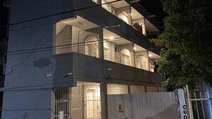 Ein mehrstöckiges Gebäude mit einem befestigten Eingang, Balkonen und einer sichtbaren Treppe.