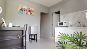 Eine moderne Küche mit Mikrowelle, Kaffeemaschine und einer Marmor-Spritzschutzwand.