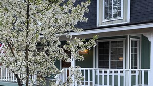 A house with a porch, a tree with white blossoms, and a sign that reads "Squirrel".
