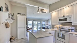 A modern kitchen with white cabinetry, a large island, a built-in oven, and a microwave. - Lakefront Bellevue Home: Private Beach & Fire Pit! (Bellevue)