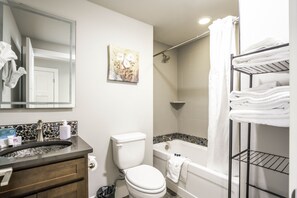 Een bad/douchecombinatie, een haardroger, handdoeken