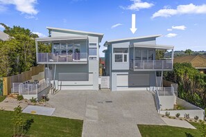 A modern two-story house with a garage, a balcony, and a fenced backyard. - Bluehaven Woolgoolga (Woolgoolga)