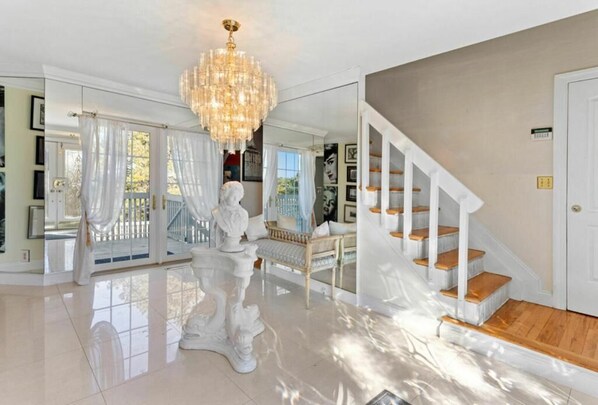 Experience the epitome of luxury with a grand chandelier, elegant staircase, and beautiful views through large windows.