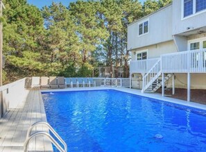 Relax by the pool surrounded by lush trees and enjoy a refreshing swim.