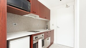 A modern kitchen with a microwave, stove, oven, and sink. - Cremorne - MP303 Military Road - Convenient Studio in the Heart of Cremorne with Shops, Dining Transport at Doorstep (Cremorne)