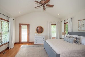 A bedroom with a bed, a ceiling fan, a dresser, and a door. - Waterfront Retreat w/ Hot Tub, Games & Views (Whiteford)