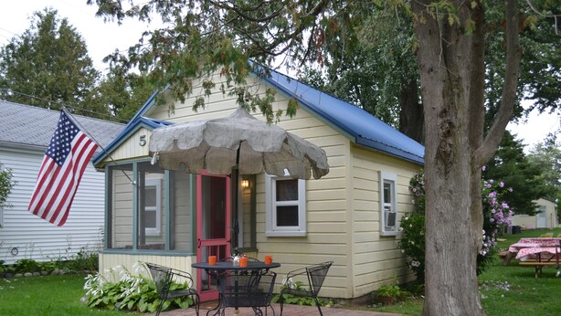 Una casa con un patio, un tavolo e sedie, e una bandiera americana.