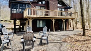 A cabin with a balcony, outdoor seating, and a forest backdrop. - Relax at Sunset View in the Hideout Resort (Lake Ariel)