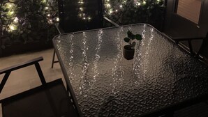 A modern kitchen with a glass-top table, a potted plant, and a wall decorated with string lights. - Relax at Sunset View in the Hideout Resort (Lake Ariel)
