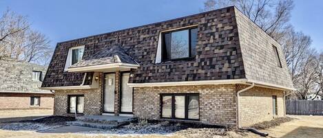 A modern two-story house with a brick exterior and a sloped roof.