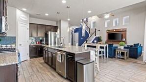 Eine moderne Küche mit Granit Arbeitsplatten, Edelstahlgeräten und einer zentralen Kochinsel.